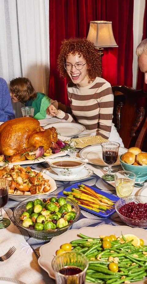 Large family gathering around a table for Thanksgiving dinner.