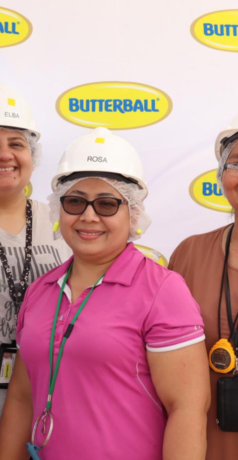 Smiling Butterball employees, wearing protective gear